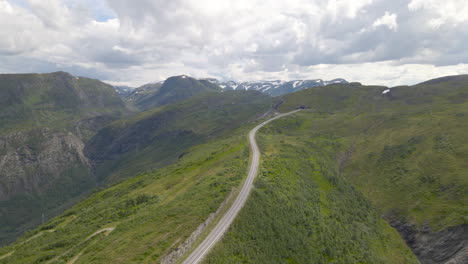 Conducción-De-Vehículos-En-Una-Larga-Y-Estrecha-Carretera-De-Montaña-Con-Cielo-Nublado-En-Vikafjell,-Noruega