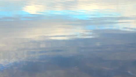 Wasserwellen-Mit-Reflexion-Des-Frühen-Morgenhimmels-In-Blauen-Und-Orangen-Farben