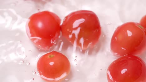 Cámara-Lenta-De-Pequeños-Tomates-Cayendo-En-Un-Recipiente-Con-Agua-Para-Limpiar