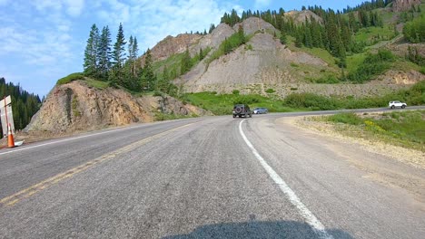 POV-while-driving-on-Million-Dollar-Highway-approaching-one-of-the-many-hairpin-curves-near-Red-Mountain-Pass-in-the-San-Juan-Mountains-part-of-the-Skyway-Colorado-Scenic-Byway-near-Silverton-Colorado