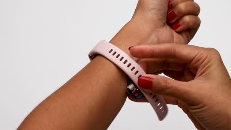 A-Woman-Places-a-Pink-Huawei-Band-6-Smartwatch-on-her-Left-Wrist-with-White-Background-Studio-Setting