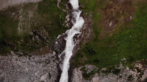 Bird's-Eye-View-Of-Waterfall-Flowing-By-The-Cliff-In-Austria