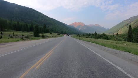 POV-while-driving-on-Million-Dollar-Highway-through-Red-Mountain-Creek-valley-with-dramatic-views-of-San-Juan-Mountains-near-Ironton-Colorado