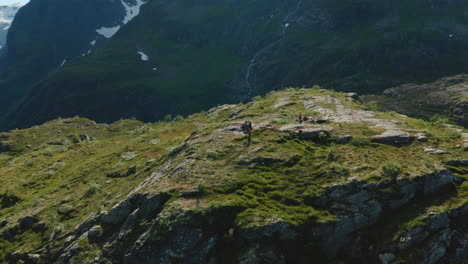 Vista-Panorámica-De-Los-Montañeros-En-La-Cima-Del-Acantilado-Y-La-Cordillera-Alpina-En-Olden,-Noruega