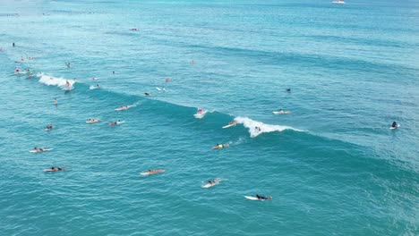 Surfers-catching-waves-and-having-a-great-time-at-a-popular-surfing-spot-all-caught-in-4k-aerial-by-a-drone