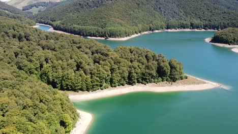 Aerial-horizontal-footage-of-a-lake-in-a-green-natural-environment-with-mountains-in-the-Spanish-Pyrenees