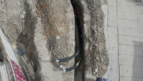 Cables-De-Tubería-Colocados-En-Una-Zanja-Excavada-En-Un-Sitio-De-Construcción