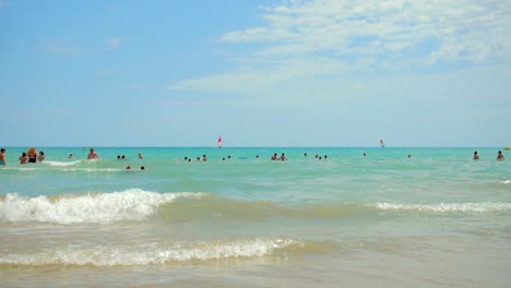 Sommerszene-Am-Strand-In-Alcossebre,-Spanien-Mit-Einer-Menschenmenge,-Die-Im-Strahlend-Blauen-Mittelmeer-Schwimmt