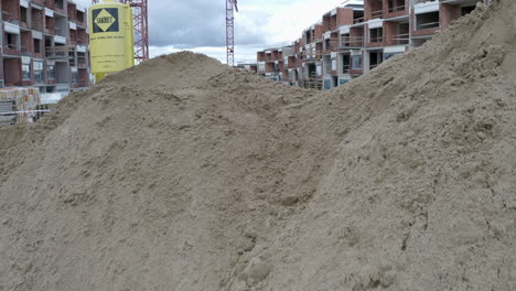 Piles-of-sand-and-dirt-at-apartment-construction-site,worker-calling