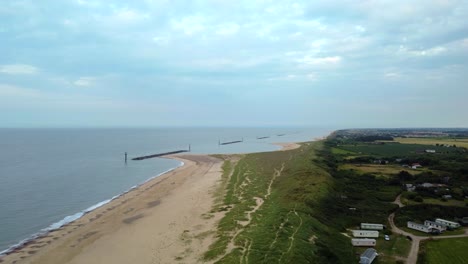 Aerial-over-beach-with-breakwater-sea-defences-in-Norfolk,-England