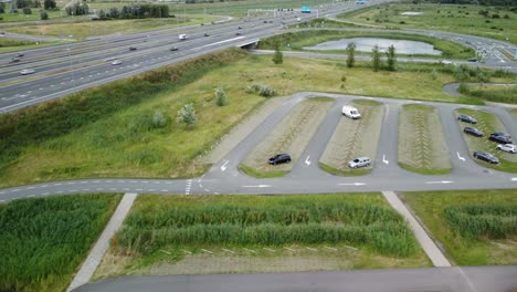 Aerial-shot-of-a-parking-lot-next-to-the-highway-A6-at-Almere