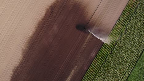 Top-View-Of-A-Farm-Sprinkler-Watering-Green-Crops-At-The-Field