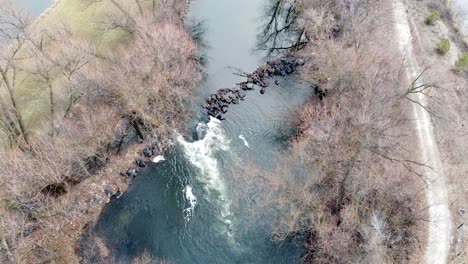 Small-river-dam-and-rapids-on-scenic,-idyllic,-willow-tree-lined-river-in-winter-in-rural-countryside-in-Boise,-Idaho,-USA
