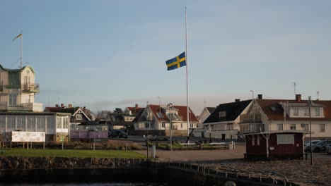 Schwedische-Flagge-Weht-Bei-Sanfter-Brise-Am-Molle-Ort-In-Hoganas,-Kreis-Skåne,-Schweden