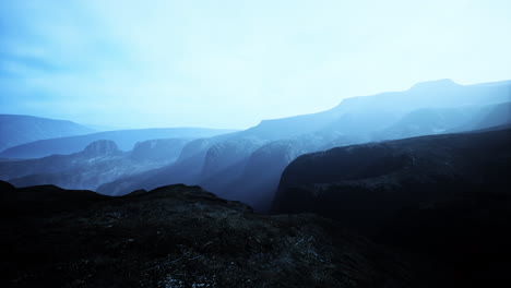 Paisaje-Atmosférico-Oscuro-Con-La-Cima-De-Una-Alta-Montaña-Negra-En-La-Niebla