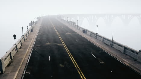 Una-Carretera-Asfaltada-Iluminada-Vacía-En-Una-Espesa-Niebla