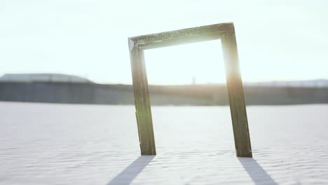 Empty-wooden-picture-frame-on-the-beach-sand