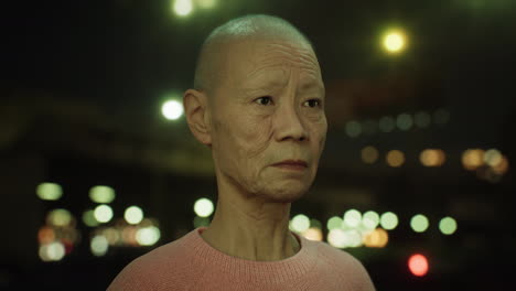 old-Asian-woman-in-city-at-night