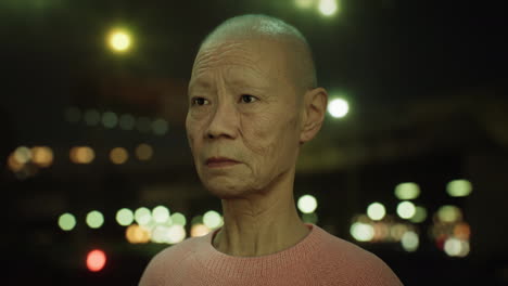 old-Asian-woman-in-city-at-night