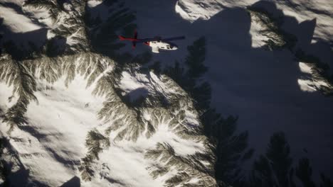 Helicóptero-Sobre-Montañas-En-La-Nieve
