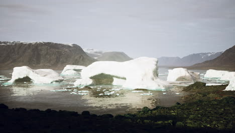 Montañas-Nevadas-E-Icebergs-A-La-Deriva-En-El-Mar-De-Groenlandia