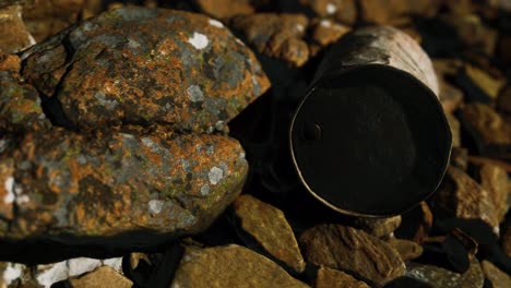 rusty-destroyed-metal-barrel-on-beach-rocks