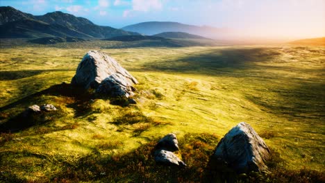 meadow-with-huge-stones-among-the-grass-on-the-hillside-at-sunset