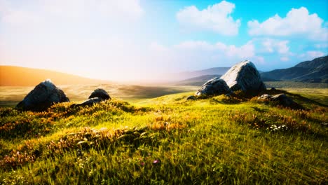 meadow-with-huge-stones-among-the-grass-on-the-hillside-at-sunset
