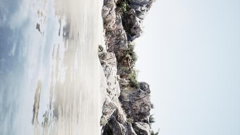 vertical-video-of-large-rock-island-in-the-middle-of-the-sea-water