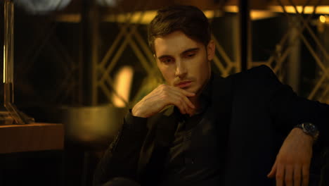 Sensual-man-looking-at-someone-in-front-of-him.-Rich-guy-sitting-in-armchair.