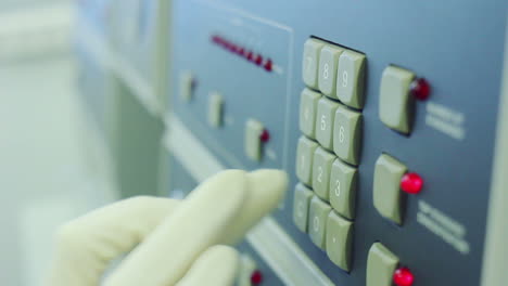 Scientist-in-white-glove-is-clicking-on-hardware-buttons-of-equipment