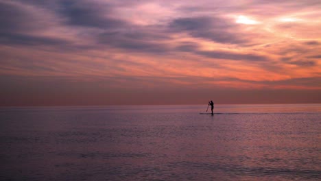 Sunset-at-sea.-Man-on-surfboard-at-sunset.-Sea-sunset.-Sunset-landscape