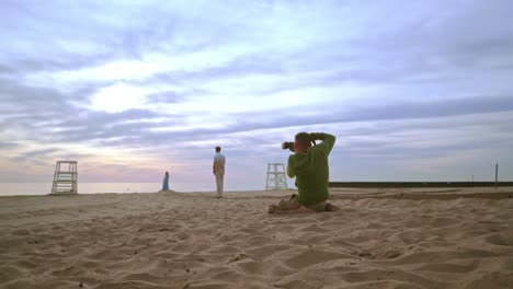 Photographer-taking-photo-of-couple-on-beach.-Romantic-photo-session