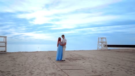 Couple-kissing-on-beach.-Pregnant-couple-on-sea-beach
