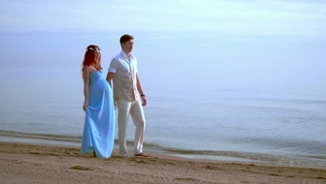Love-couple-walking-on-beach.-Pregnant-couple-walking-beach.-Couple-beach