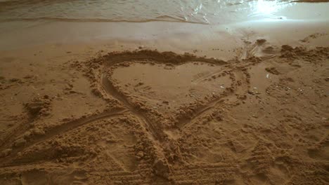 Heart-shape-on-beach-sand.-Steady-shot.-Heart-draw-on-sand-beach