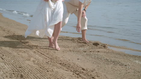 Pregnant-couple-having-fun-on-beach.-Feet-of-couple-on-beach