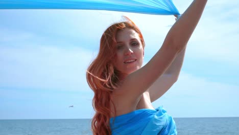 Sensual-woman-with-blue-cloth-flying-on-wind.-Woman-portrait.-Redhead-women