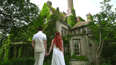 Honeymoon-couple-looking-at-beautiful-country-house.-Fairytale-house
