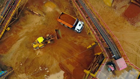 Excavator-loader-load-sand-in-dumper-truck.-Aerial-view.-Sand-work