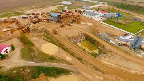 Aerial-view-of-dump-trucks-with-sand-standing-on-territory-industrial-factory