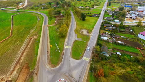Drone-view-of-suburban-road-construction.-Cargo-trucks-driving-on-country-road