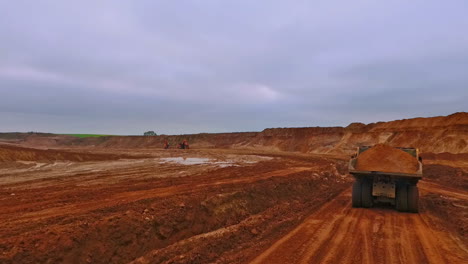 Dumper-truck-moving-along-sand-quarry.-Aerial-view-of-dump-truck
