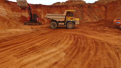 Mining-truck-moving-at-sand-mine.-Mining-machinery-working-at-sand-quarry