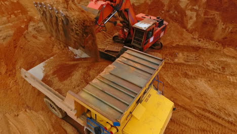 Mining-excavator-loading-sand-in-dumper-truck-at-sand-quarry.-Excavator-bucket