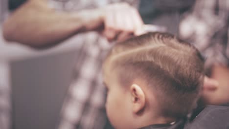 Child-hairstyle.-Kids-hair-cut.-Stylist-combing-hair-child.-Child-hair-cut