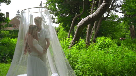 Pregnant-couple-posing-under-under-wedding-canopy-at-park