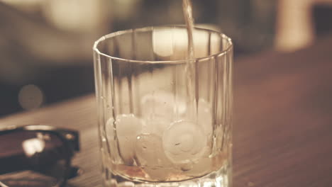 Hipster-drink.-Pouring-cola-in-glass-with-ice.-Whisky-glass.-Ice-drink
