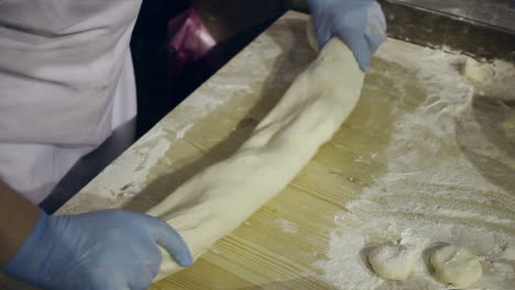 Making-dough-at-kitchen.-Chef-hands-kneading-dough.-Hands-form-raw-dough