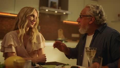 Portrait-of-cheerful-adult-daughter-and-senior-father-sitting-at-dining-table